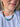 A close-up of a woman wearing a multi-strand beaded necklace with turquoise, dark green, brown, and white beads, paired with a white t-shirt.